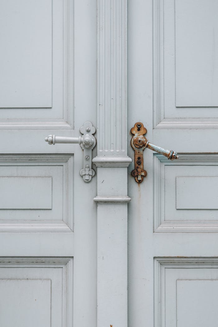 Close-up of a vintage blue wooden door featuring ornate metal handles. Perfect for architectural themes.