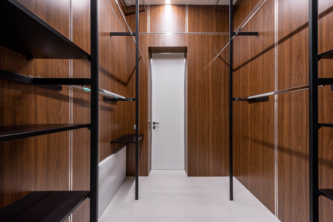 services-01 A sleek and modern walk-in closet with wood paneling and black accents.
