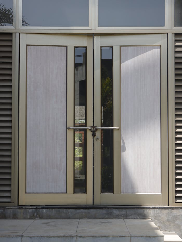 Contemporary glass and metal double doors leading into an urban building.